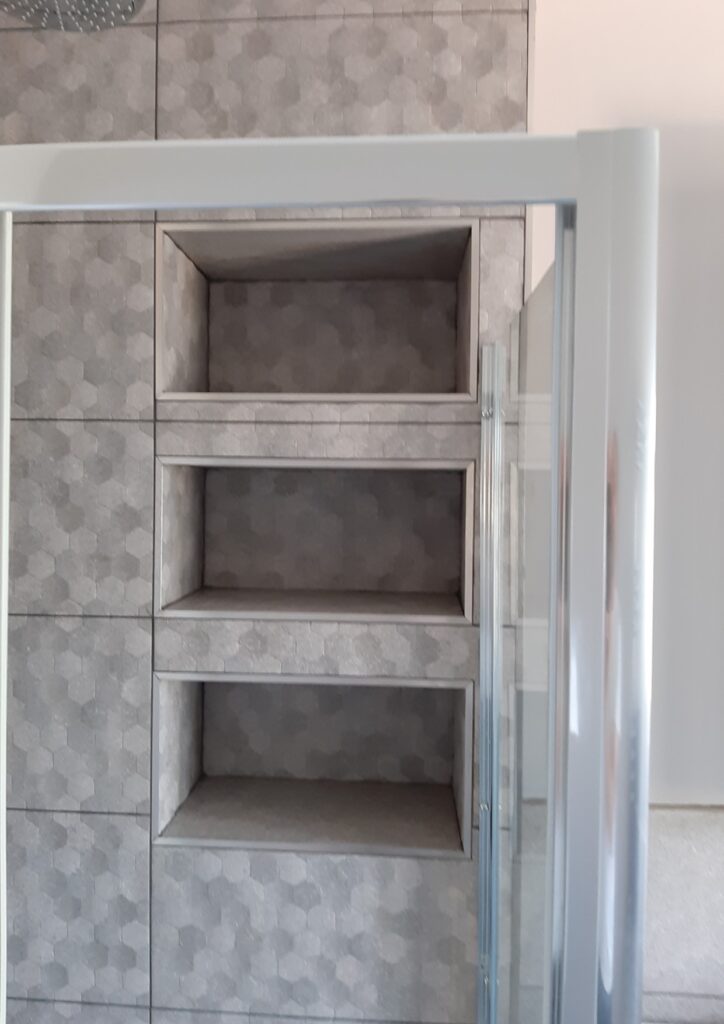 Built-in recessed shelving and storage niches in small bathroom renovation Kingston upon Thames.