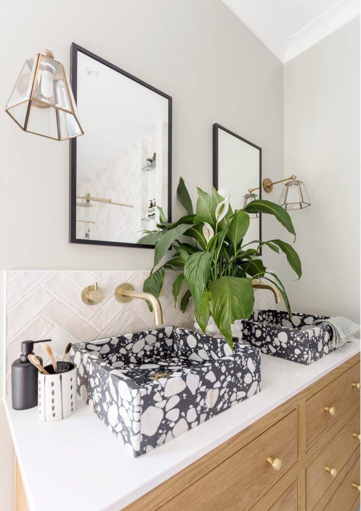 Brass fixtures, textured tiles, and greenery styled in small Surrey bathroom renovation by professional Installers. .