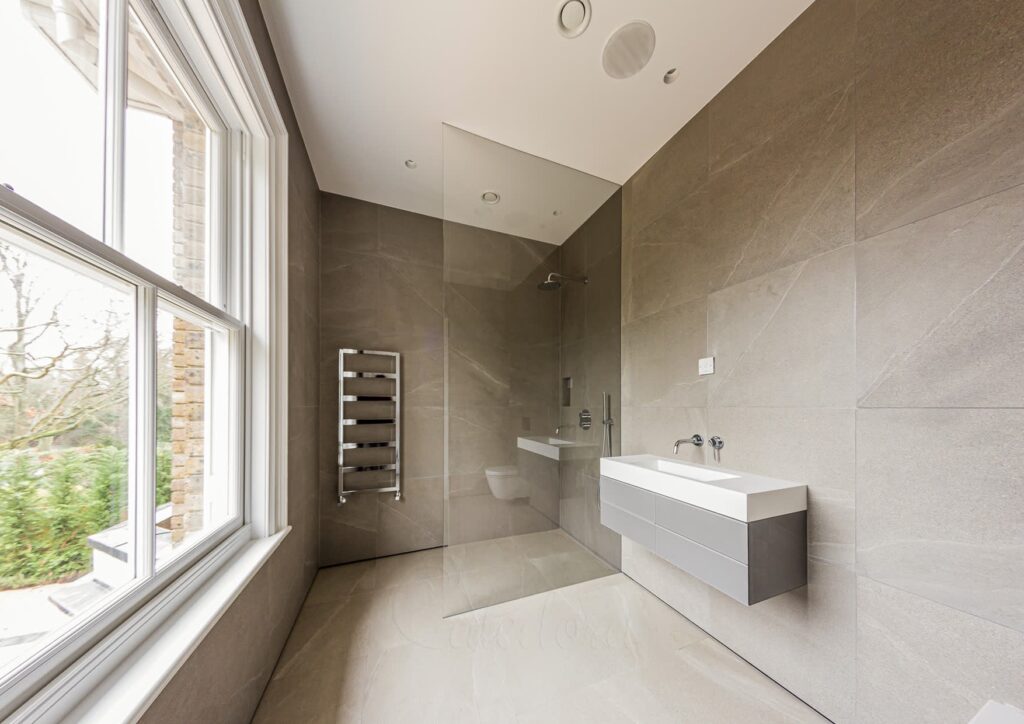 Contemporary walk-in shower with frameless glass panels in Surrey home, installed by professional bathroom fitters.